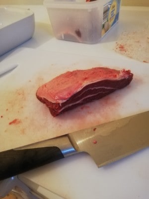 A chunky portion of beef with a couple of layers of fat going through it