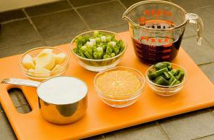 A chopping board with a jug of Teriyaki sauce on it.